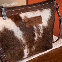 Wrangler crossbody wristlet bag made of genuine hair-on cowhide with brown PU leather trim and detachable strap.