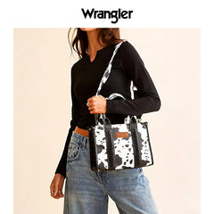 Person holding a cow print handbag with Wrangler logo