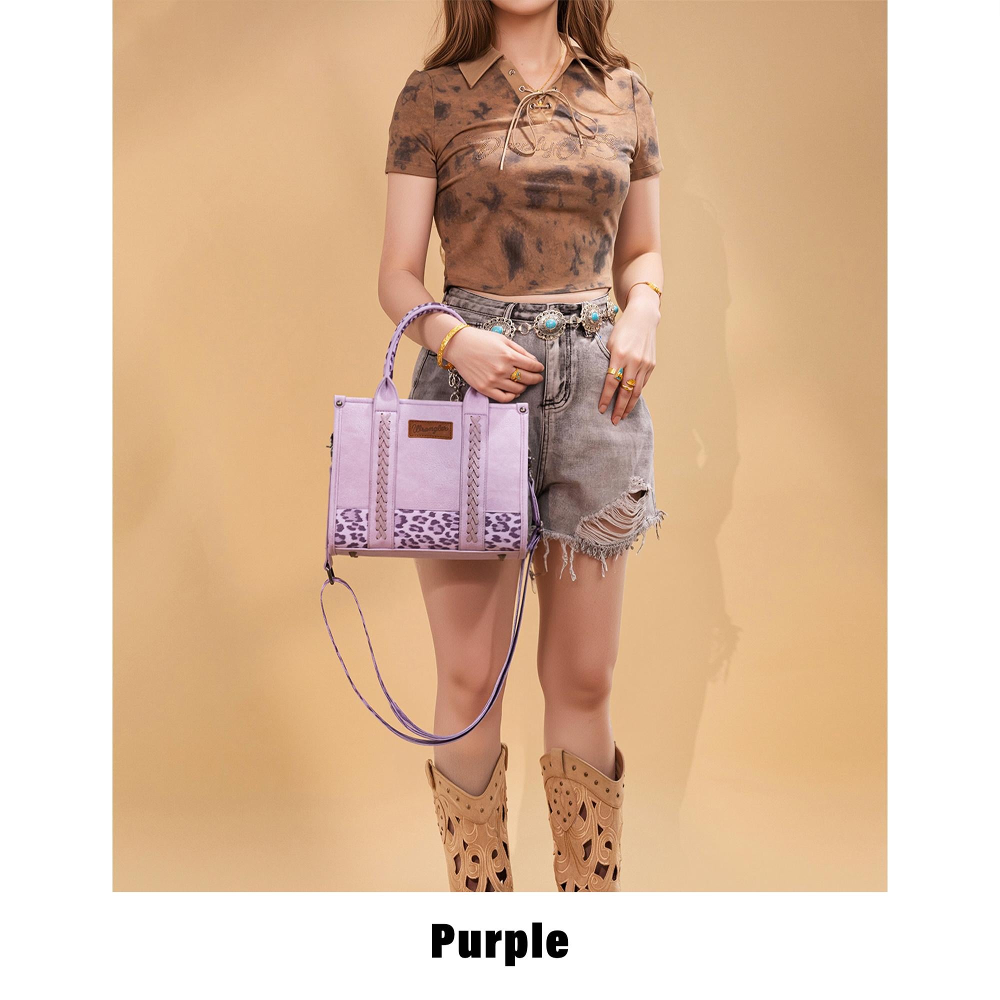 Woman styling the Wrangler purple leopard crossbody tote bag with Western boots and distressed denim shorts, showcasing everyday Western cowgirl fashion.