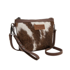Wrangler crossbody wristlet bag made of genuine hair-on cowhide with brown PU leather trim and detachable strap.
