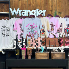 Wrangler 5-piece mystery box display with best-selling cow print mugs, graphic tees, Wrangler crossbody tote bags, hair clips and cow-hide key chains. 