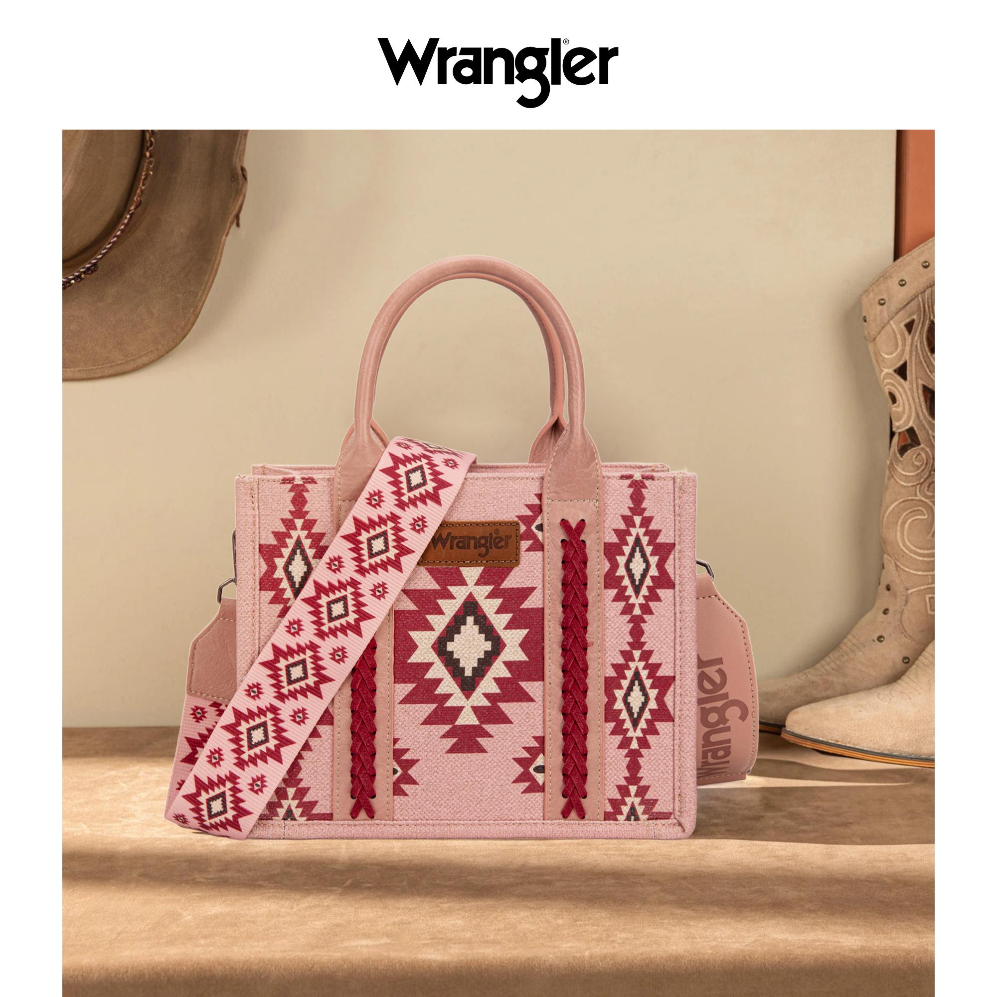 Pink handbag with patterned strap and 'Wrangler' branding on a wooden surface.