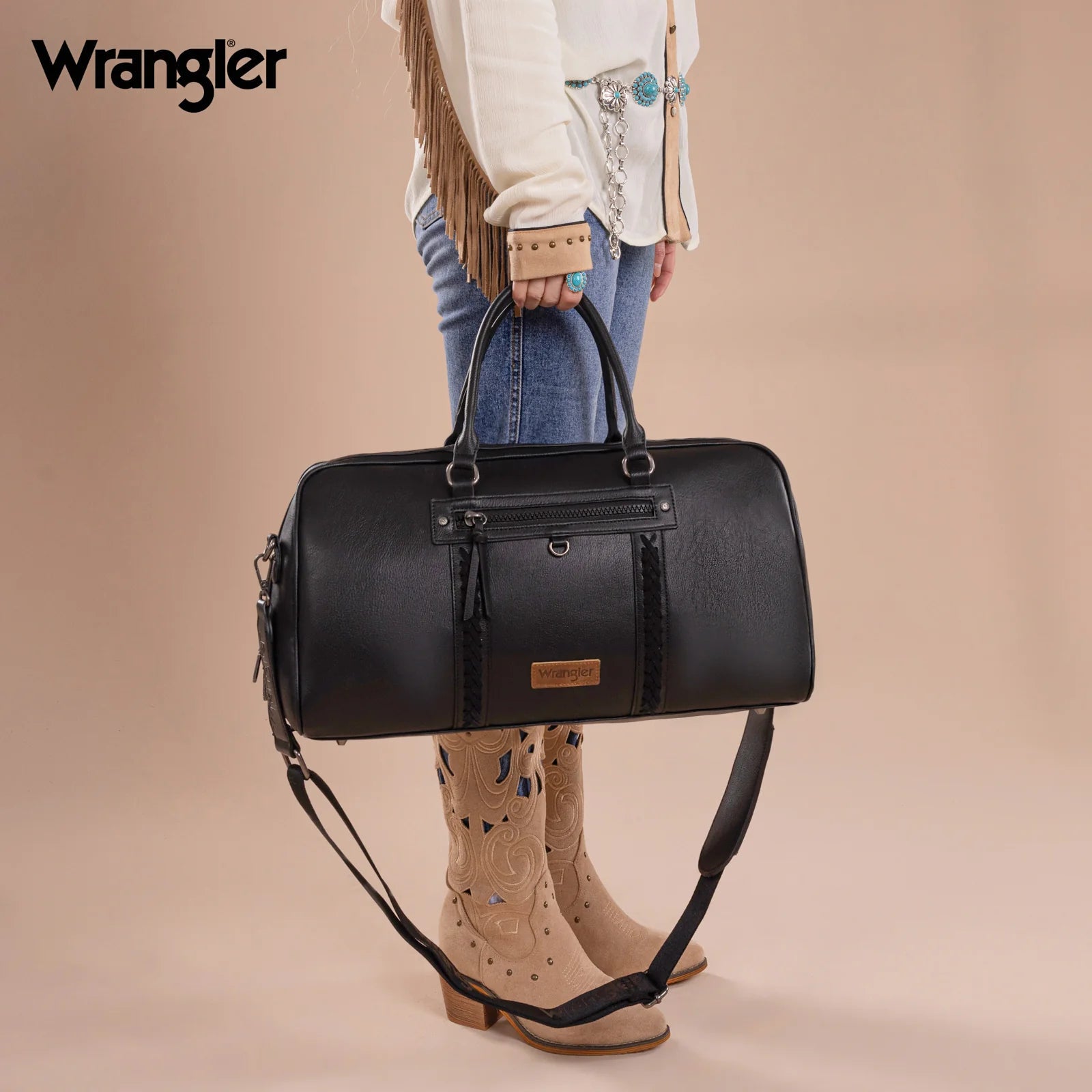 Cowgirl holding a black Wrangler whipstitch duffle bag with guitar strap – styled with Western boots and denim, perfect for weekend travel.
