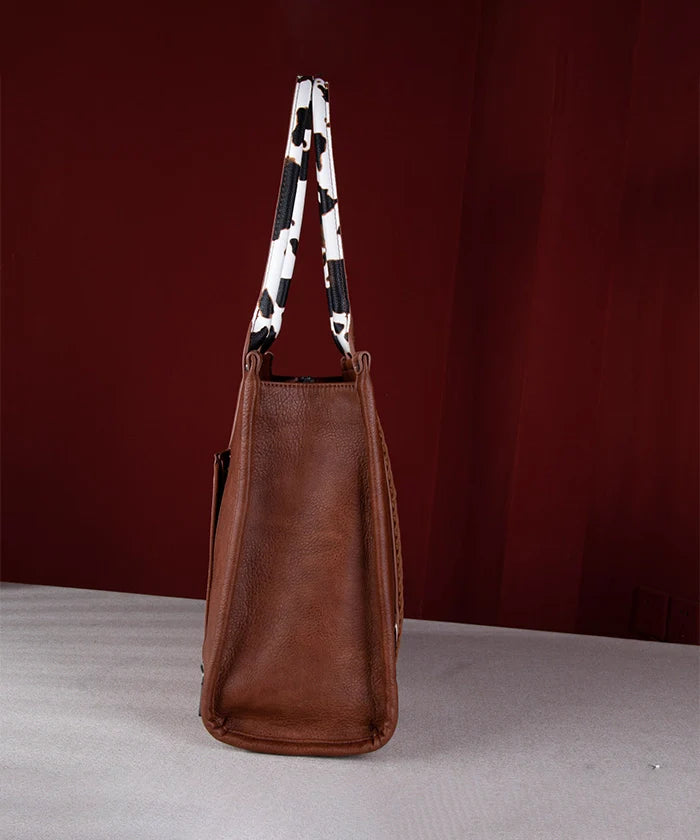 Side view of Wrangler cow print purse showing slim profile and dual cowhide-style handles
